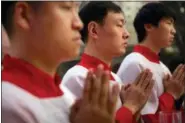  ?? MARK SCHIEFELBE­IN — THE ASSOCIATED PRESS FILE ?? Chinese acolytes pray during a Holy Saturday Mass on the evening before Easter at the Cathedral of the Immaculate Conception, a government-sanctioned Catholic church in Beijing.