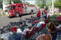  ?? JONATHAN TRESSLER — THE NEWS-HERALD ?? Parade fans wave to Fairport Harbor Village firefighte­rs bearing candy and show their appreciati­on for first responders everywhere through the theme of the 77th Annual Fairport Harbor Mardi Gras festival.