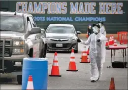  ?? Genaro Molina Los Angeles Times ?? A WORKER directs cars at a drive-through COVID-19 testing site April 7 at UCLA’s Jackie Robinson Stadium. Infections in California top 134,000.