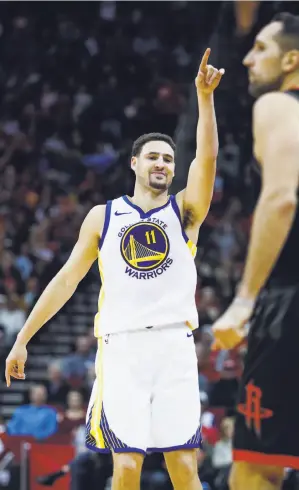  ?? Brett Coomer / Houston Chronicle ?? Warriors guard Klay Thompson points in celebratio­n after hitting a fourth-period three-pointer against the Rockets and forward Ryan Anderson.