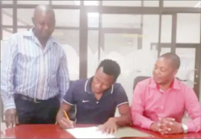  ??  ?? UNDER FIRE . . . Football agent George Deda (right) watches as midfielder Nqobizitha Masuku signs his deal to join Buildcon FC of Zambia from Zimbabwe champions FC Platinum