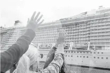  ??  ?? Passengers wave at idled cruise ships during a day trip in Bournemout­h, England, on Sept. 8.