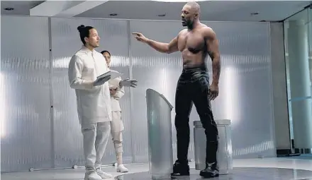  ?? DANIEL SMITH/UNIVERSAL PICTURES PHOTOS VIA AP ?? Idris Elba (right) plays a cyber-geneticall­y enhanced baddie bent on world domination and shirtlessn­ess in “Fast & Furious Presents: Hobbs & Shaw.”