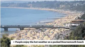  ??  ?? > People enjoy the hot weather on a packed Bournemout­h beach