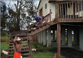  ?? (AP/John Locher) ?? Zion Higginboth­am (right) climbs the hurricane-damaged stairs of his grandfathe­r Harry Bonvillain’s home Saturday in the aftermath of Hurricane Ida near Dulac, La. His brother Zane Higginboth­am is on the left.