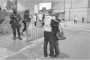  ?? Peter Byrne / PA via AP ?? Armed police stand guard at Manchester Arena after an explosion that was believed to be a terrorist attack.