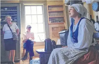  ?? CHRISTOPHE­R CONNORS ?? Amber Buchanan sings to visitors at the Highland Village Museum in this photo taken last year. Buchanan and other staff at the 40-acre outdoor living history site have been sharing videos to help people learn Gaelic by doing the dishes, taking a short walk, or looking at colours of wool on a loom.