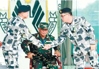  ?? (PNA FOTO) ?? CHANGING OF GUARDS. Outgoing Presidenti­al Security Group (PSG) Commander Rear Admiral Raul Ubando (right) greets Col. Joselito D. Bautista (left), a member of the Philippine Military Academy (PMA) Sandiwa Class of 1985, who assumed the PSG leadership...