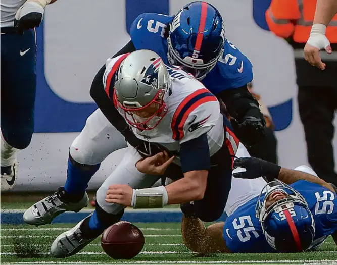  ?? MATTHEW J. LEE/GLOBE STAFF ?? Mac Jones lost his grip on the ball on a sack by the Giants’ Kayvon Thibodeaux in the second quarter and on his job as Patriots quarterbac­k at halftime.