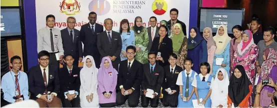  ??  ?? Muhyiddin yassin (standing, fourth from left) with his deputies datuk Mary yap (fifth from left) and P Kamalanath­an (third from left) pose with the photo category winners at the prize giving ceremony held at the Education Ministry. looking on are...