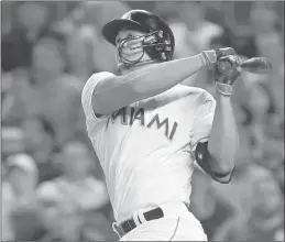  ?? AlAn DiAz / AP ?? The Miami Marlins’ Giancarlo Stanton is just one of many athletes forgoing fashion for safety. He is wearing a cheek-covering extension on his helmet after losing a good part of last season when he took a pitch to his face.