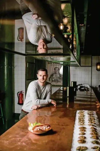  ?? (EDDY MOTTAZ/LE TEMPS) ?? Marc Gouzer dans son bar à huîtres de Genève, où le crustacé est servi dans un pain brioché, accompagné d’une mayonnaise aérienne.