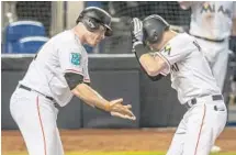  ?? SAM NAVARRO/TNS ?? Miami first baseman Justin Bour, left, congratula­tes Brian Anderson after Anderson’s home run in the fifth inning Sunday.