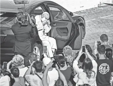  ?? VINCENZO PINTO/AFP VIA GETTY IMAGES ?? Pope Francis takes off his face mask as he arrives by car to hold a limited public audience at the San Damaso courtyard in The Vatican on Sept. 9 during the COVID-19 pandemic.