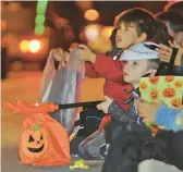  ?? JOHN RUCOSKY/THE TRIBUNE-DEMOCRAT ?? Trick-or-treaters collect candy last week in Johnstown, Pa. Some firms are trying to make it easier to recycle all those wrappers.