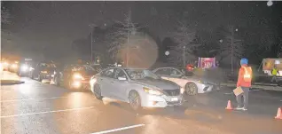  ??  ?? Cars wait to drive through the Grace Pointe Community Church of the Nazarene living Nativity.