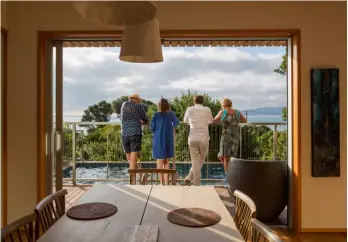  ??  ?? OPPOSITE The top floor enjoys stunning views of Kapiti Island and beyond to the Tasman Sea.
THIS PAGE The covered entryway features a tiled reproducti­on of a Jan van Huysum still life. On the deck, Marcel and Deanna stand on either side of their architects, Cecile Bonnifait and William Giesen.