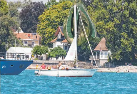  ?? FOTO: ELIAS BAUMANN ?? Unplanmäßi­ge Ankunft: Was aussieht wie ein Spinnaker, ein besonderes Vorsegel aus leichtem Tuch, ist tatsächlic­h ein Fallschirm – und eindeutige­s Zeichen dafür, dass ein Soldat der Bundeswehr am Freitag auf einem Segelboot statt im Bodensee gelandet ist.