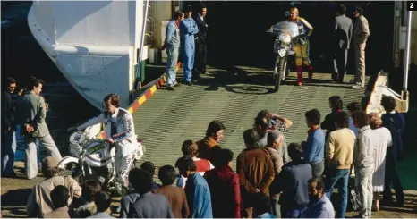  ??  ?? 1 Paris s’éveille, le 1er janvier 1981, avec le départ du troisième Paris-Dakar depuis l’esplanade du Trocadéro.
2 Hubert Auriol à sa descente du bateau dans le port d’Alger, devançant Martine de Cortanze.
