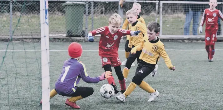  ??  ?? Silksworth Reds Under-7s (red) go on the attack against Crook Town Panthers.