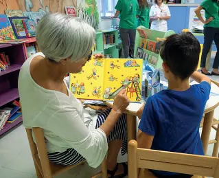  ??  ?? La sala Un piccolo paziente della pediatria del Sant’Orsola legge un libro illustrato insieme a una sua parente
