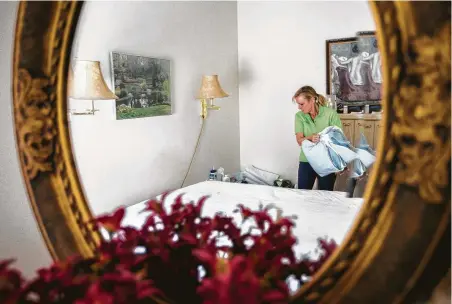  ?? Marie D. De Jesús / Staff photograph­er ?? Roewe changes the bedsheets for an elderly client at his Tomball home. “I feel like I’m an extension of their normal life,” she says.