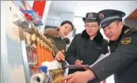  ?? LI XIN / FOR CHINA DAILY ?? Inspectors check the quality of heating devices in Huaibei, Anhui province, in December.