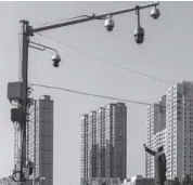  ?? Bloomberg photo ?? Surveillan­ce cameras in front of a statue of former chinese leader Mao Zedong and buildings in Fuxin, liaoning province, china.