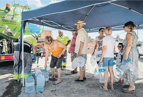  ?? Xa i Juri ?? Vecinos de L’Albi, en Les Garrigues, llenando sus garrafas con la cuba de agua que llega al pueblo un día a la semana