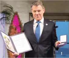  ?? — Reuters ?? Colombian President Juan Manuel Santos poses with the medal and diploma during the Peace Prize awarding ceremony on Saturday.