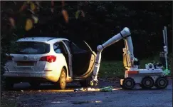  ??  ?? Terror: The taxi is searched for explosives by a police robot