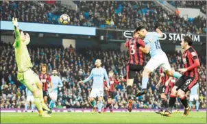  ?? OLI SCARFF/AFP ?? Manchester City striker Sergio Aguero heads in his side’s third goal during their English Premier League match against Bournemout­h at the Etihad on Saturday.