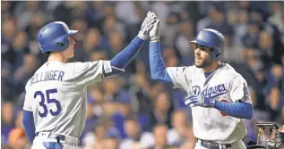  ?? DENNIS WIERZBICKI, USA TODAY SPORTS ?? The Dodgers’ Chris Taylor celebrates with Cody Bellinger after hitting a solo home run against the Cubs on Tuesday night in Chicago.