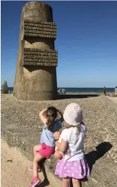  ??  ?? The children gaze at the D-Day memorial on Omaha Beach in Normandy. Below, the same beach on June 6, 1944