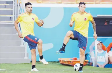  ?? Ap / eugene hoshiko ?? Radamel Falcao (izquierda) y James Rodríguez calientan previo al entrenamie­nto de ayer en Saransk. Rodríguez no pudo completar la práctica por dolencias.