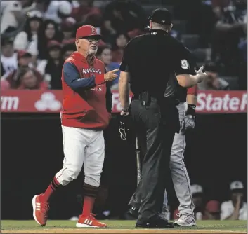  ?? ASHLEY LANDIS/AP ?? LOS ANGELES ANGELS’ MANAGER JOE MADDON, left, disputes a stolen base call during the fifth inning of a baseball game against the Boston Red Sox in Anaheim on Monday.