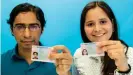  ??  ?? Un joven de India y una chica de Venezuela muestran sus permisos de residencia alemanes.