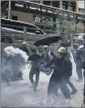  ??  ?? CLASHES: Protesters face police tear gas in Hong Kong, yesterday, as demonstrat­ors flooded streets.