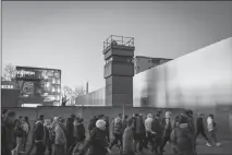  ?? GORDON WELTERS / THE NEW YORK TIMES ?? Pedestrian­s pass the Berlin Wall Memorial on Feb. 6 in Berlin. The wall has been down for exactly as long as it was up, as of this month.