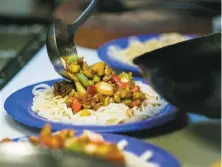  ?? Photos by Jen Fedrizzi / Special to The Chronicle ?? Laghman noodles are plated, above, at Uyghur Taamliri in the Sunset District. Left: Bahtiyar Tursun strings noodles in the kitchen he runs with his son, Zulpukar “Carl” Bahtiyar. They started the pop-up because they missed the food of their native...