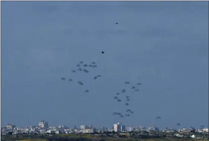  ?? MAYA ALLERUZZO - THE ASSOCIATED PRESS ?? Parachutes drop supplies into the northern Gaza Strip, as seen from southern Israel, on Thursday.