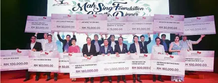  ??  ?? Generous gesture: Leong (front row, fifth from left) and Syed Norulzaman (on Leong’s left) posing with others with the mock cheques from top donors.