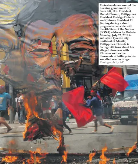  ??  ?? Protesters dance around the burning giant mural of, from left, U.S. President Donald Trump, Philippine­s President Rodrigo Duterte and Chinese President Xi Jinping during a short program to coincide with the 4th State of the Nation (SONA) address by Duterte Monday, July 22, 2019 in suburban Quezon city, northeast of Manila, Philippine­s. Duterte is facing criticisms about his alleged closeness with China as well as the thousands of killings in his so-called war on drugs. Photograph by AP