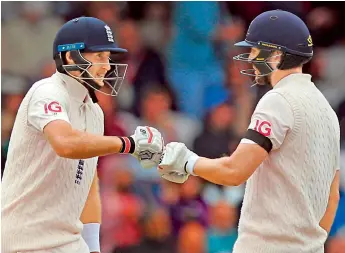  ?? —
AFP ?? England captain Joe Root (left) and Dawid Malan touch gloves as they talk between overs on the second day of the third Test against India at Headingley cricket ground in Leeds, northern England, on Thursday.