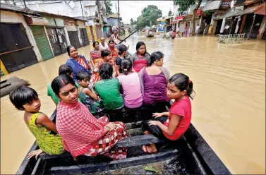  ??  ?? People use a boat as they try to move to safer places along a flooded street in West Midnapore district, in West Bengal, on Thursday.