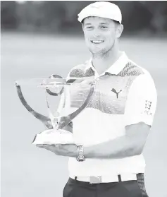  ?? — AFP photo ?? DeChambeau celebrates with the winner’s trophy after the final round ofThe NorthernTr­ust at the Ridgewood Championsh­ip Course in Ridgewood, New Jersey.