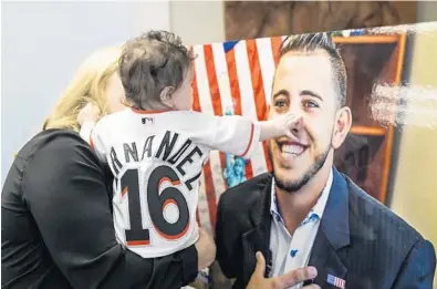  ?? SEBASTIAN BALLESTAS/MIAMI HERALD ?? Five-month-old Penelope Fernandez touches a portrait of her father during his birthday commemorat­ion at Kiwanis of Little Havana on Monday in Miami. Jose Fernandez would have been 25 years old.