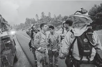  ?? NOAH BERGER THE ASSOCIATED PRESS ?? Firefighte­rs discuss plans while battling the Carr fire in Shasta, Calif., on Thursday.