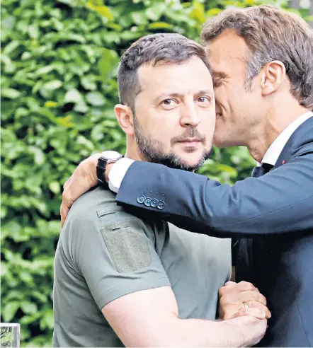 ?? ?? Volodymyr Zelensky and Emmanuel Macron embrace after the leaders of France, Germany and Italy yesterday vowed to help Ukraine beat Russia and rebuild its shattered cities