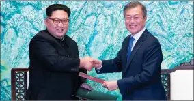  ?? KOREA SUMMIT PRESS POOL VIA AP ?? North Korean leader Kim Jong Un, left, and South Korean President Moon Jaein shake hands April 27 after signing a joint statement at the border village of Panmunjom in the Demilitari­zed Zone, South Korea. Seoul says North Korean leader Kim plans to...